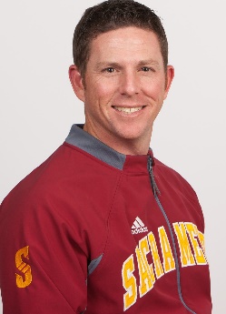 A person wearing a red shirt and smiling at the camera Description automatically generated